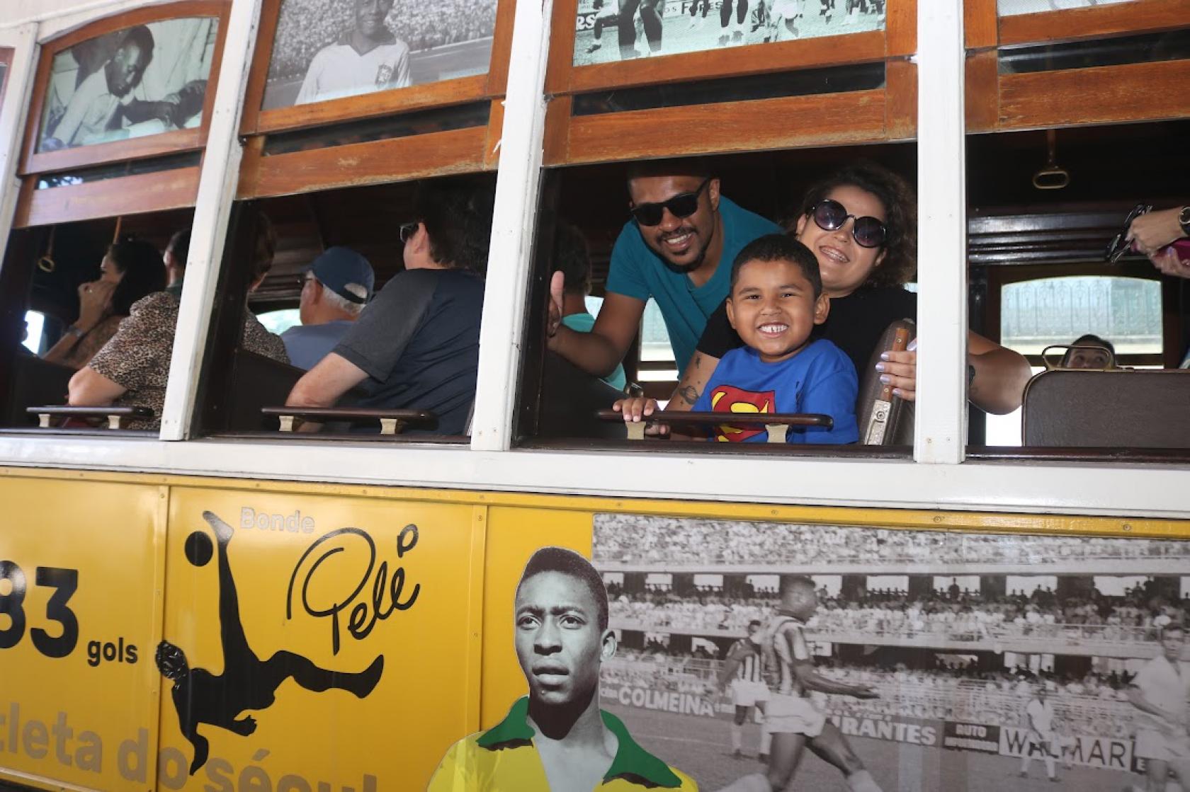 pessoas sorriem na janela do bonde #paratodosverem