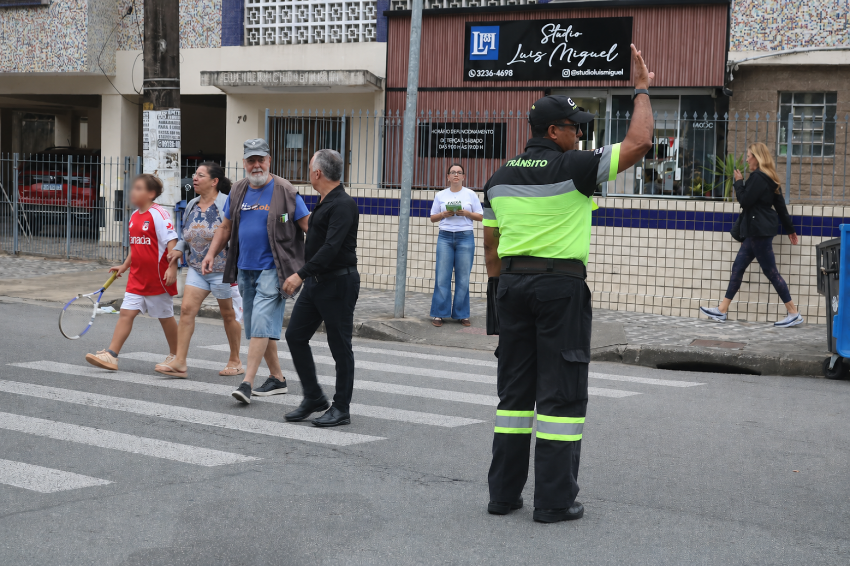 agente auxilia pessoas na travessia #paratodosverem
