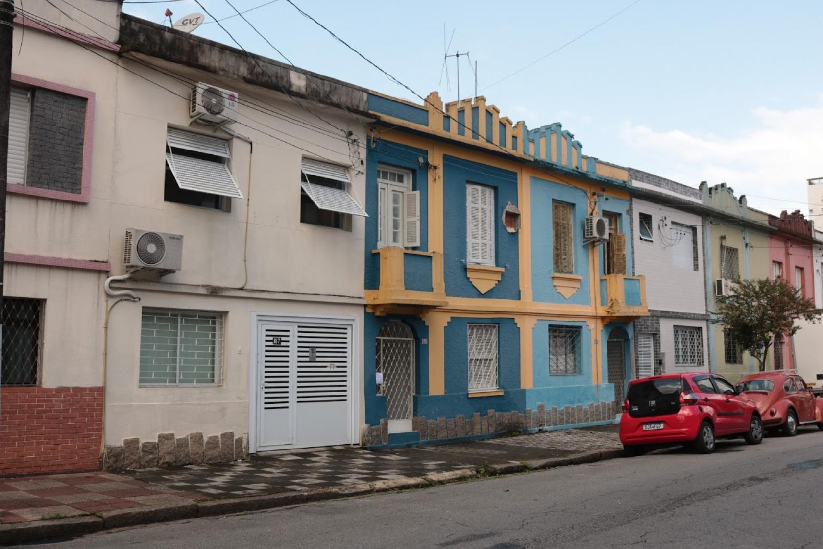 Rua com sobrados de fachadas coloridas. #paratodosverem