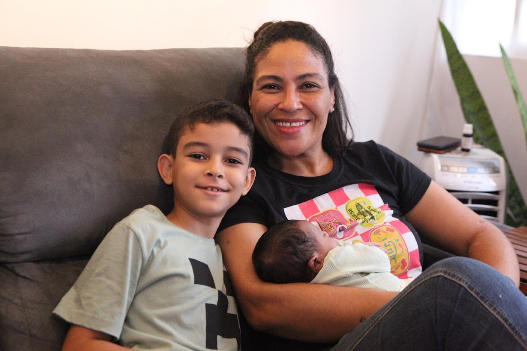 mulher abraça bebe e o filho #paratodosverem