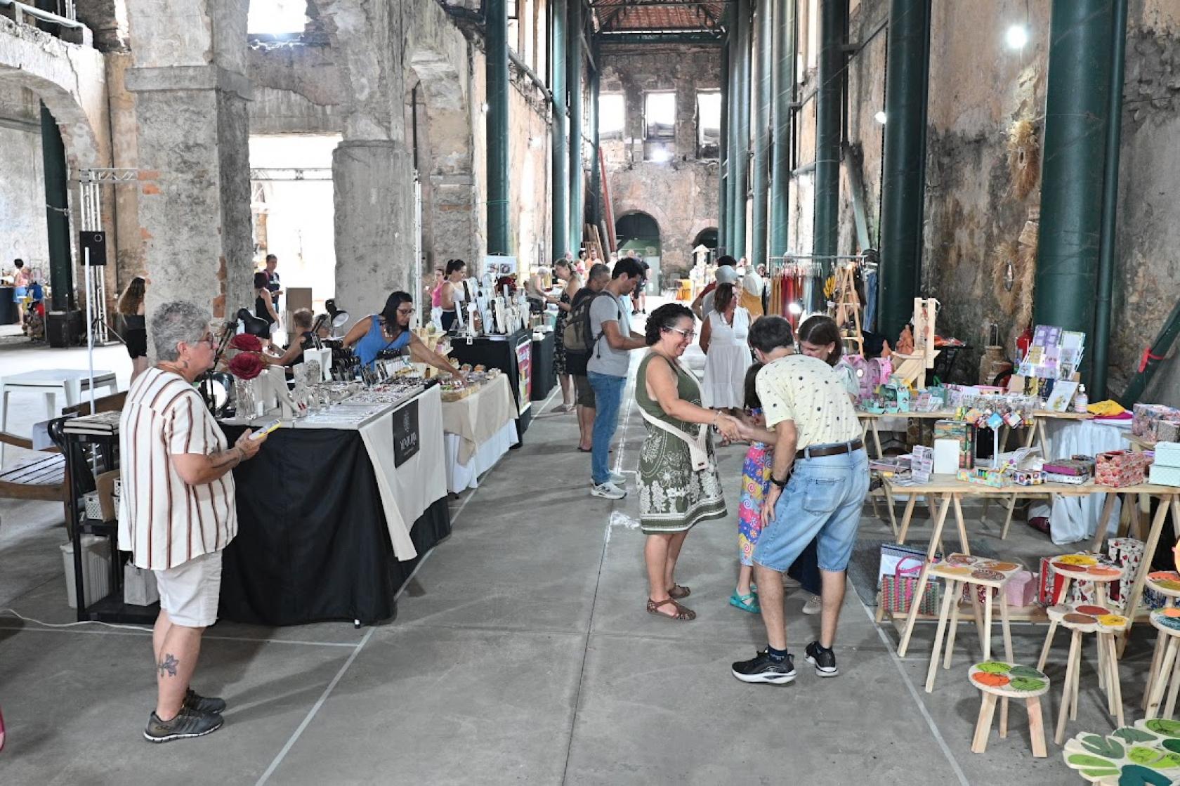 pessoas olhando produtos em feira #paratodosverem