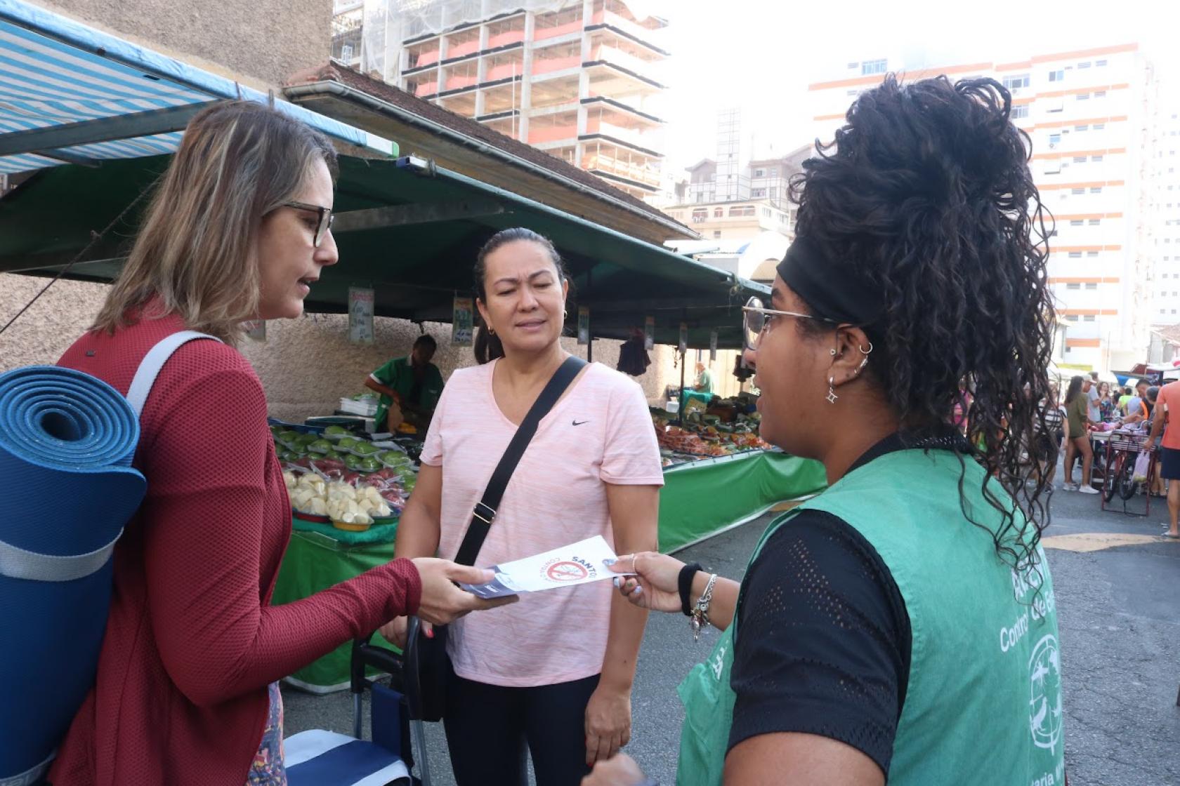 agente distribui panfletos em feira #paratodosverem 