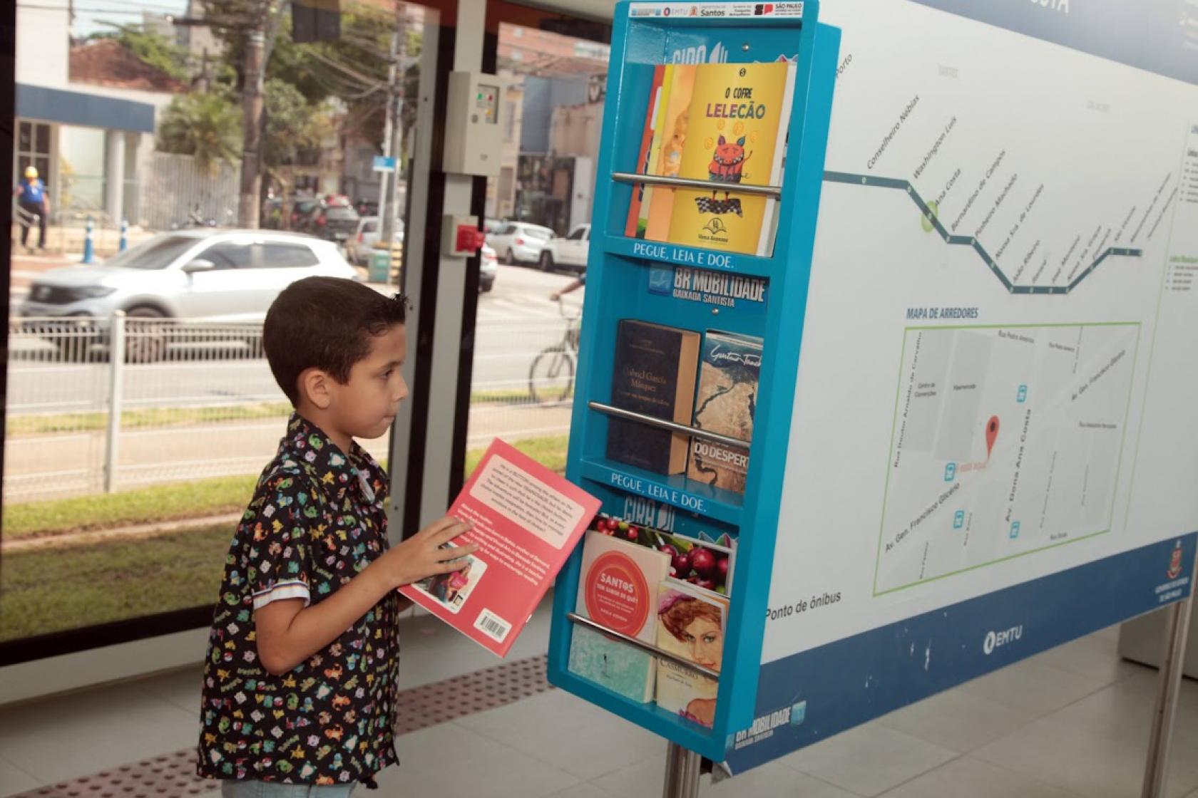 menino retira livro de estante #paratodosverem 