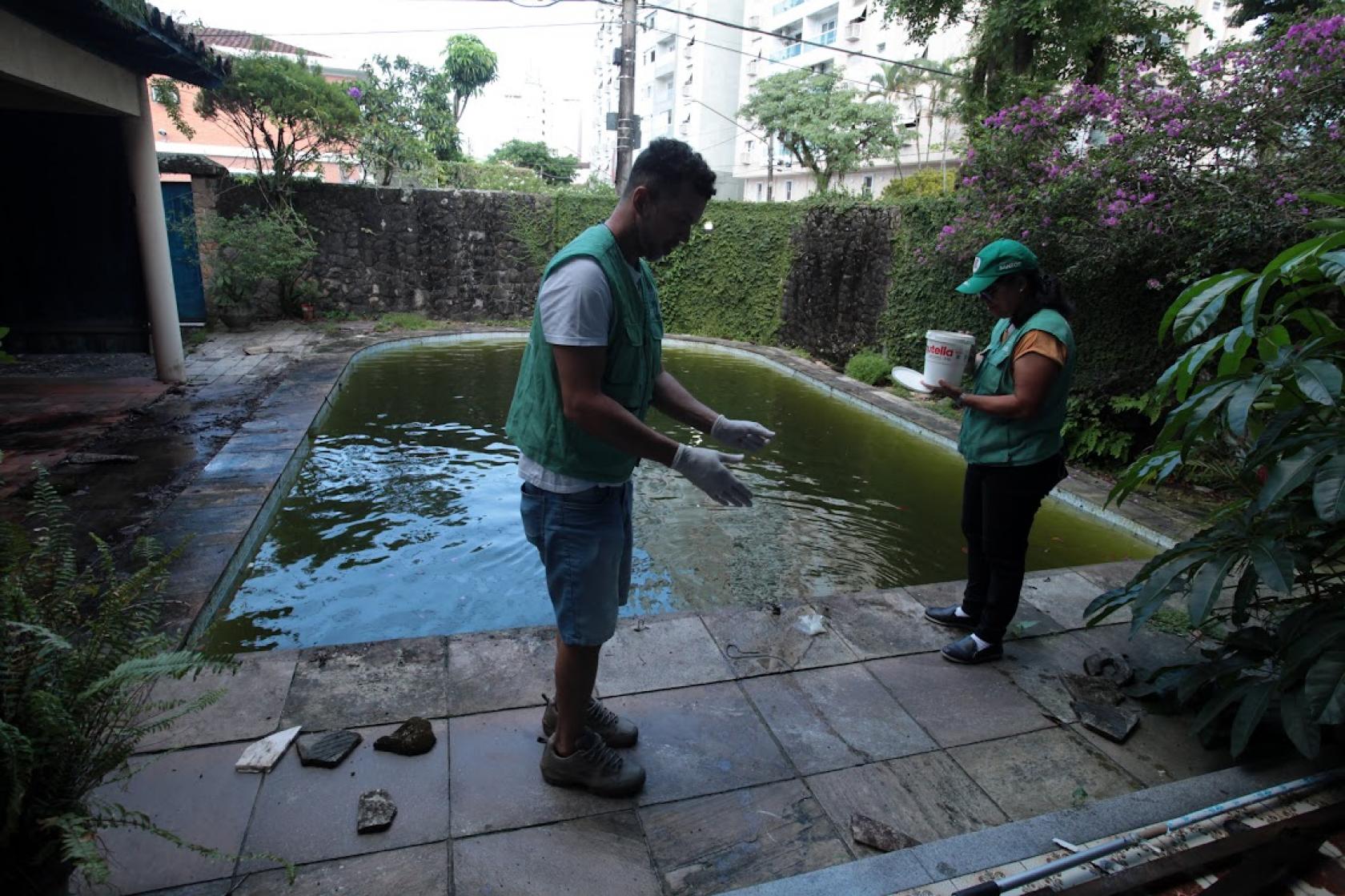 agentes colocam peixes em piscina #paratodosverem