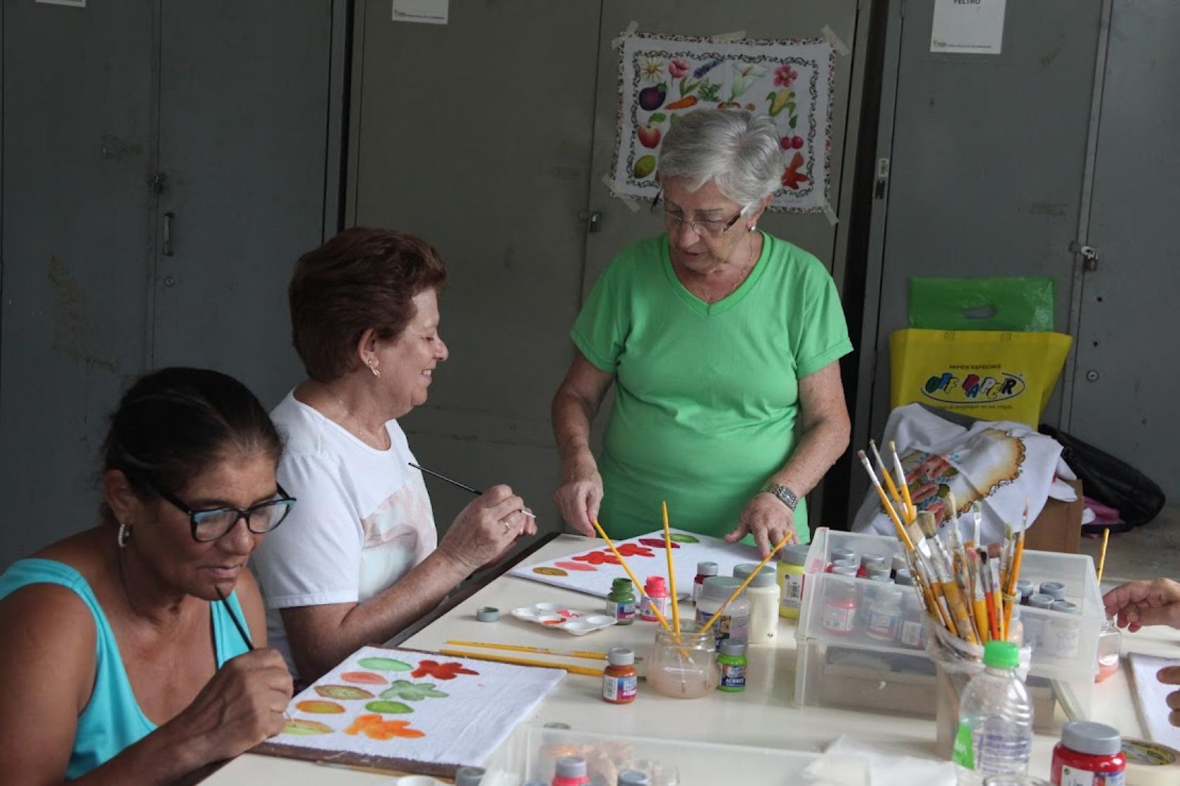 professora dá aula de pintura para alunoas #paratodosverem