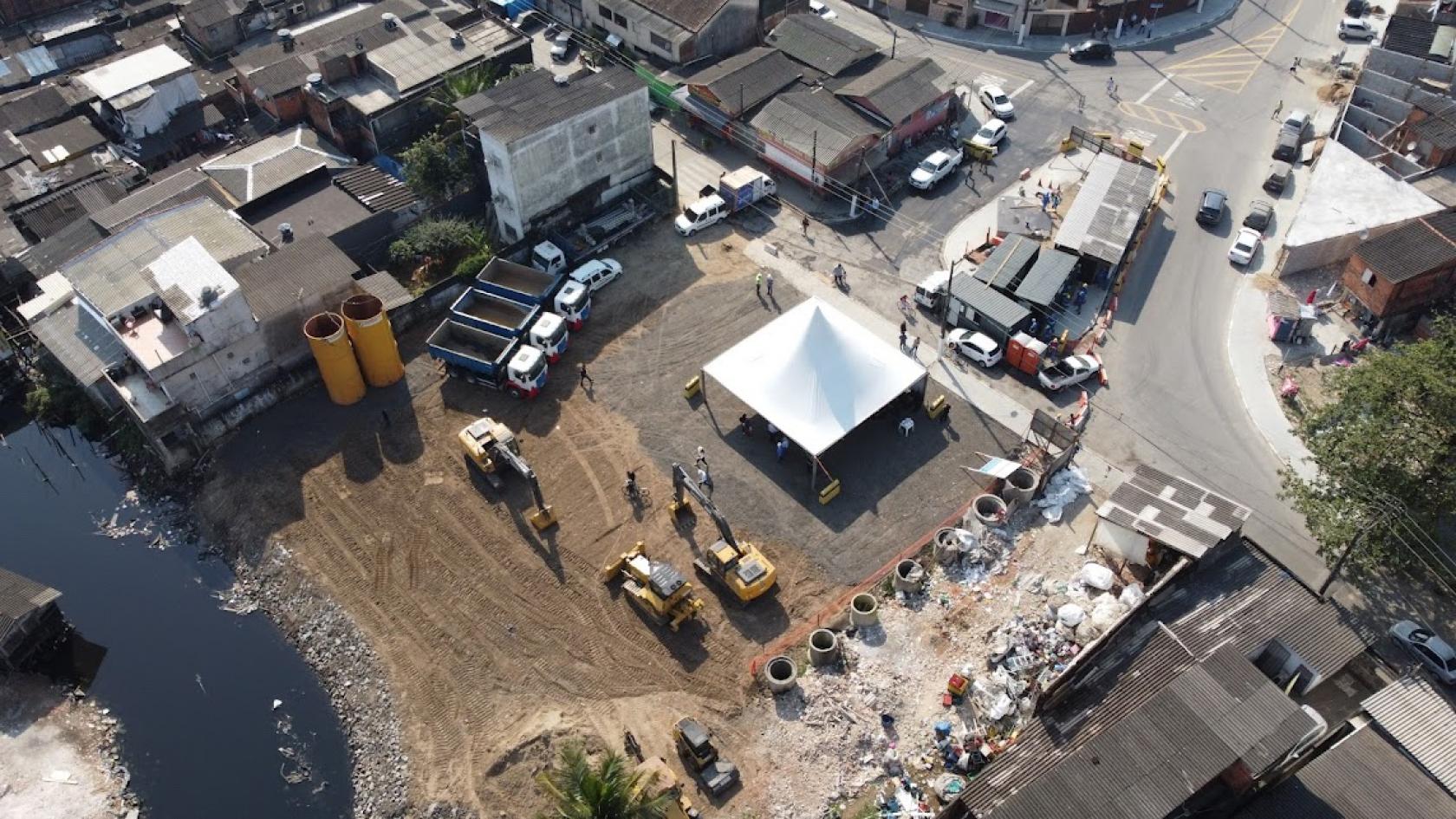 vista aérea de canteiro de obras, com caminhões e retroescavadeiras. #paratodosverem