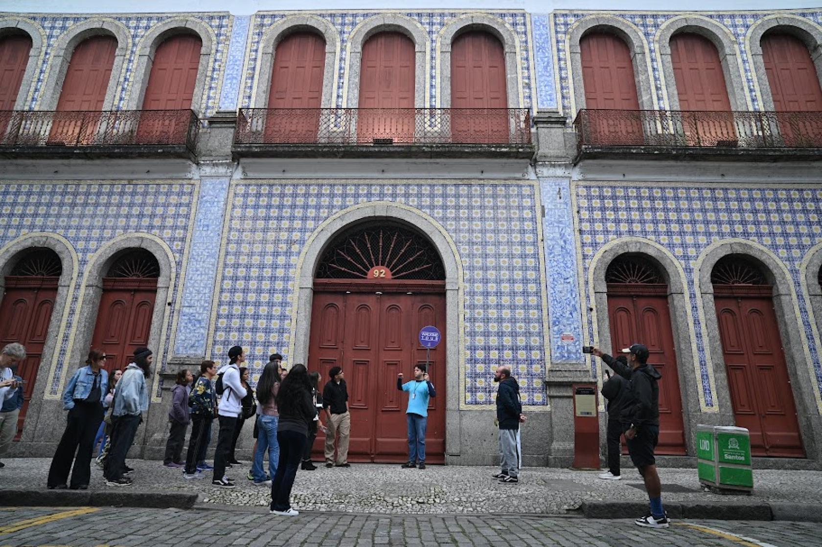 guia e turistas na frente de casa da frontaria azulejada #paratodosverem