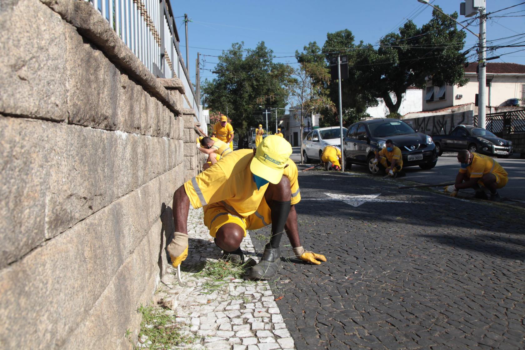 operários capinam calçada #paratodosverem