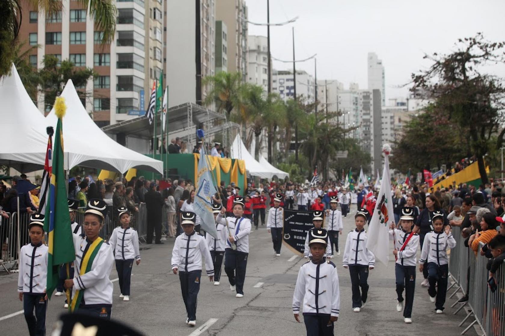 crianças desfilam pela avenida com bandeiras #paratodosverem 