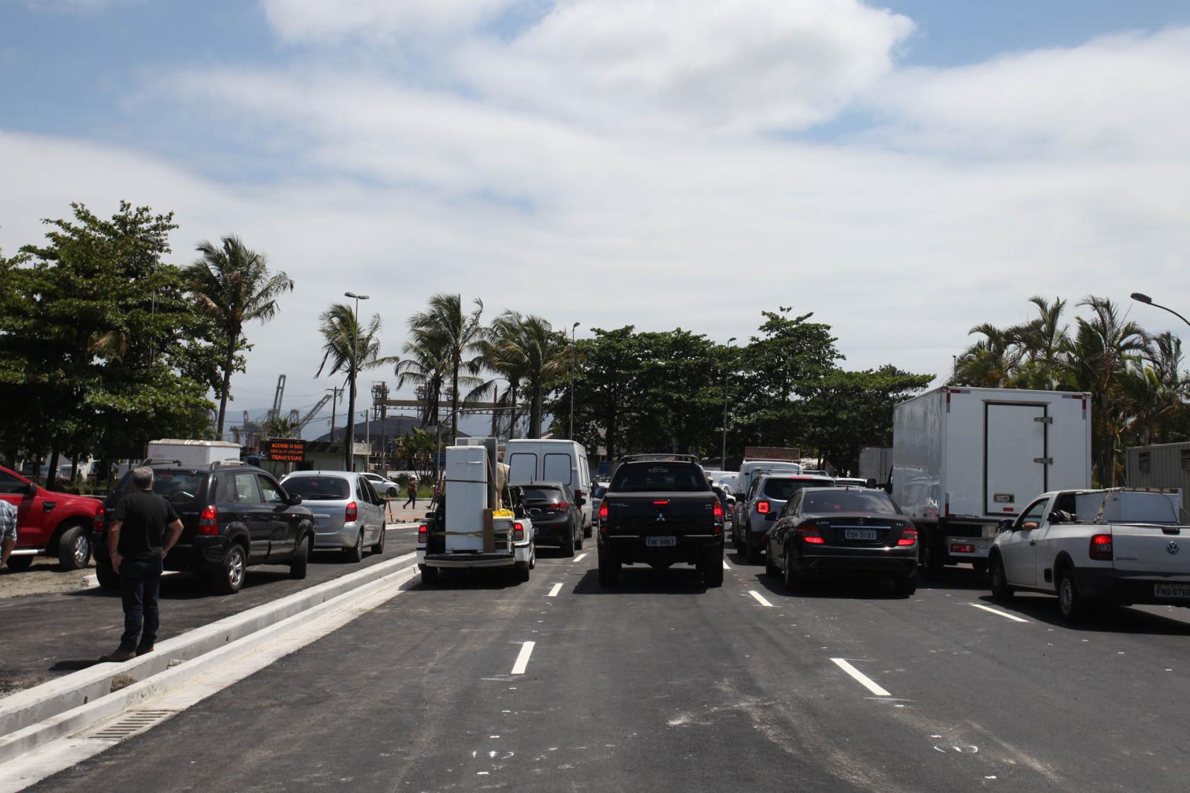 Vista geral do bolsão com sete pistas. Há filas de veículos no local. #Pracegover