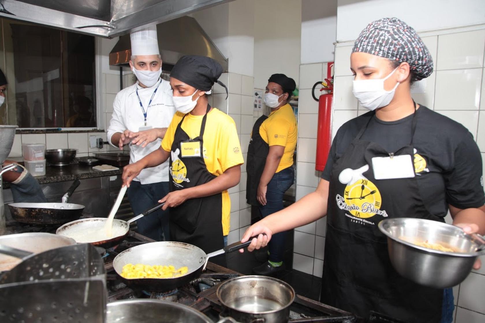 alunos cozinham supervisionados por professor #paratodosverem 