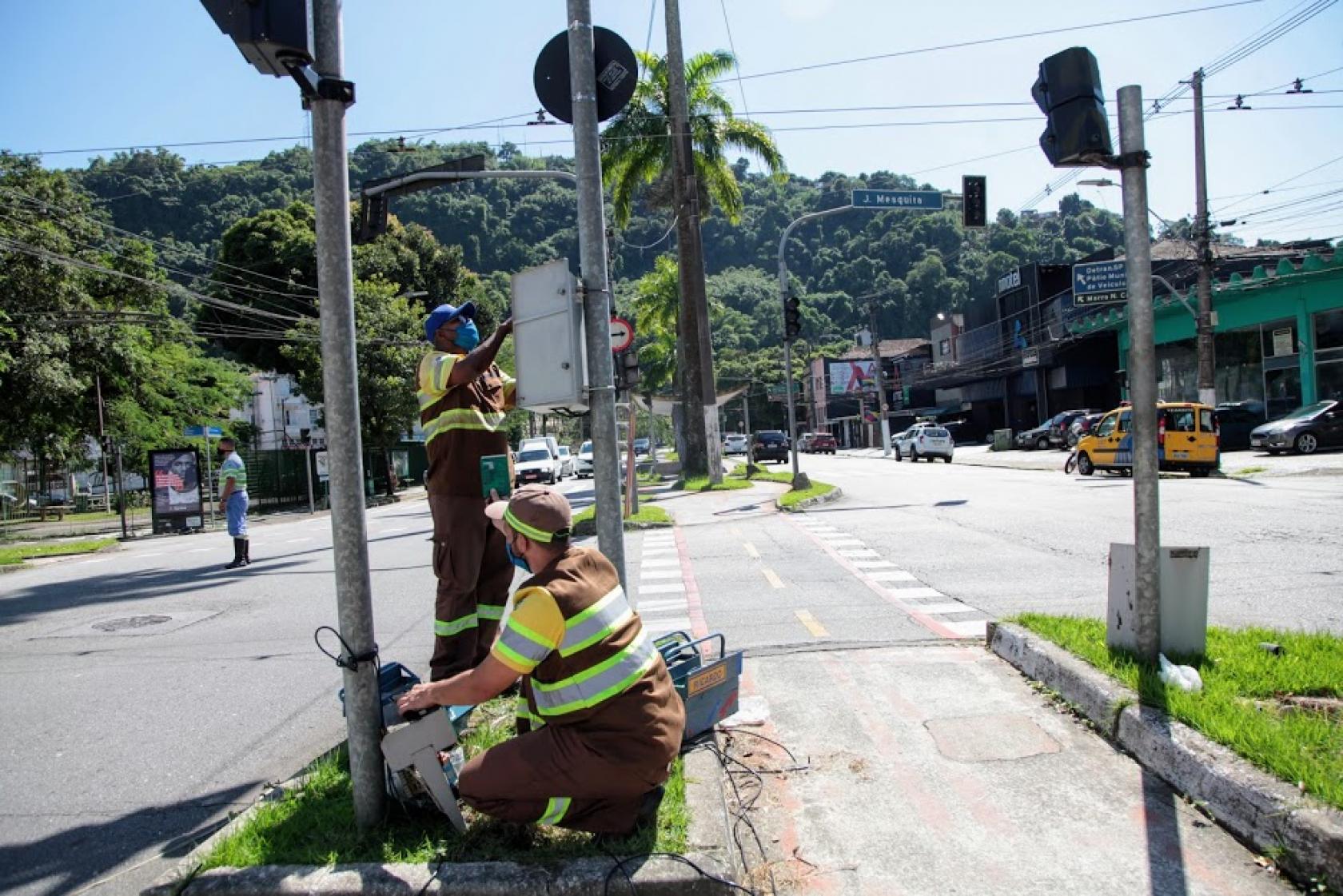 dois agentes mexem em caixa de semáforo #paratodosverem
