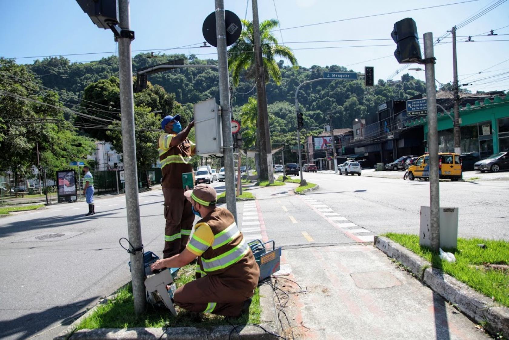 dois agentes mexem em caixa de semáforo #paratodosverem 