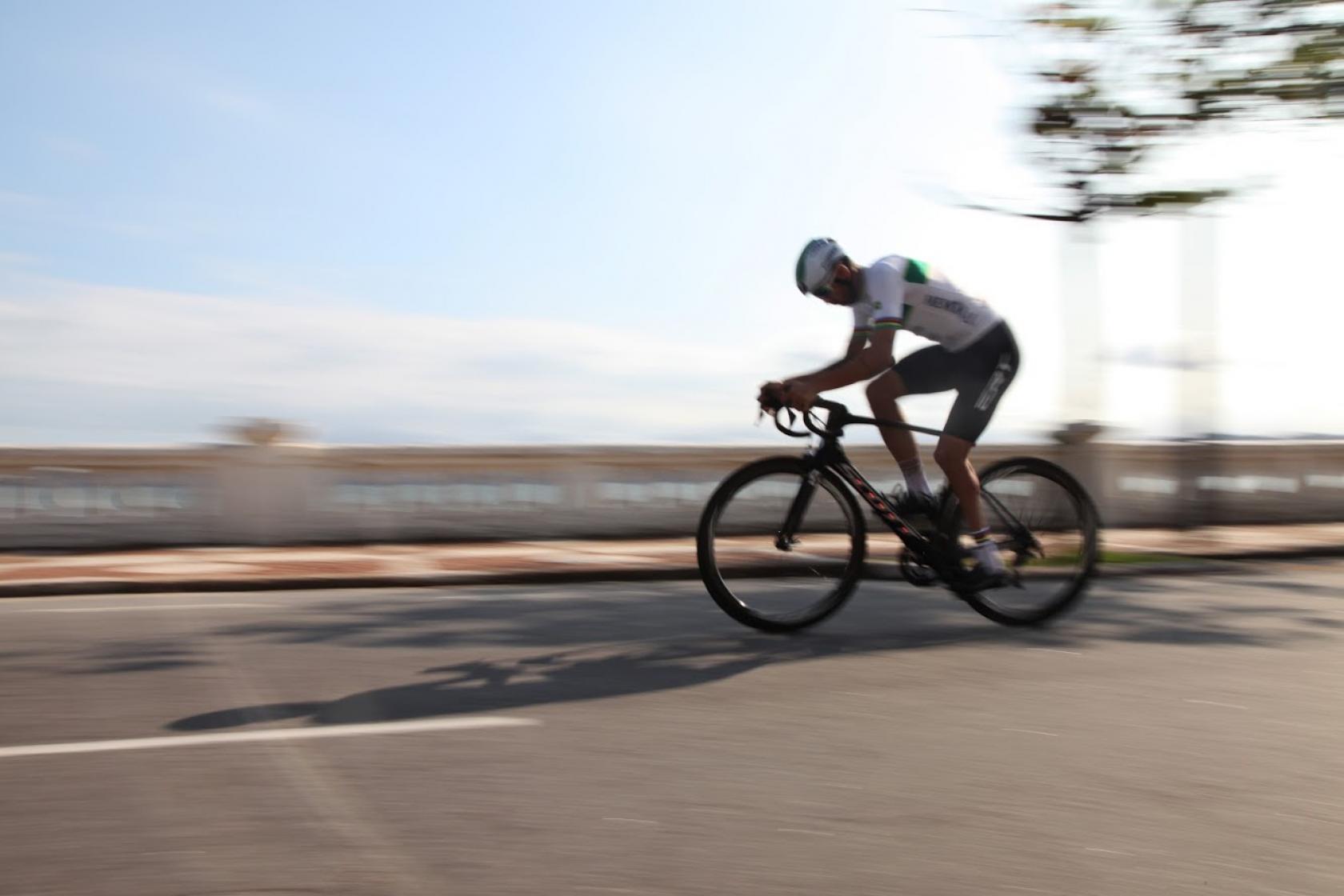 lauro chama está pedalando na ponta da praia. A velocidade da bike distorce, na imagem, as muretas ao fundo. #partodosverem