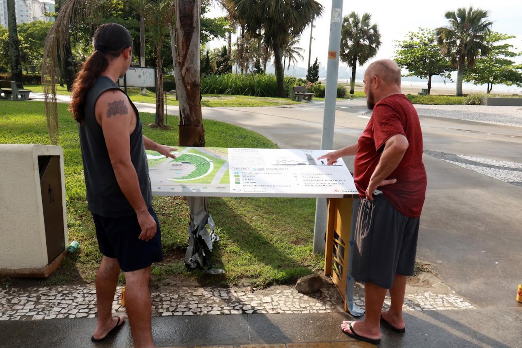 pessoas olhando os novos mapas #paratodosverem 