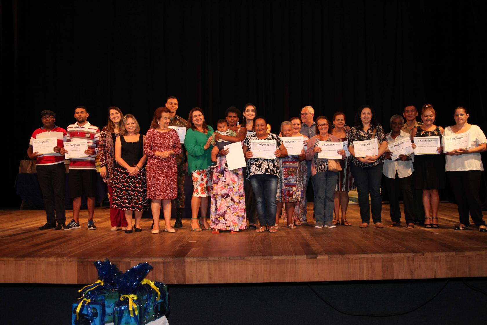 formandos mostram certificados no palco #pracegover