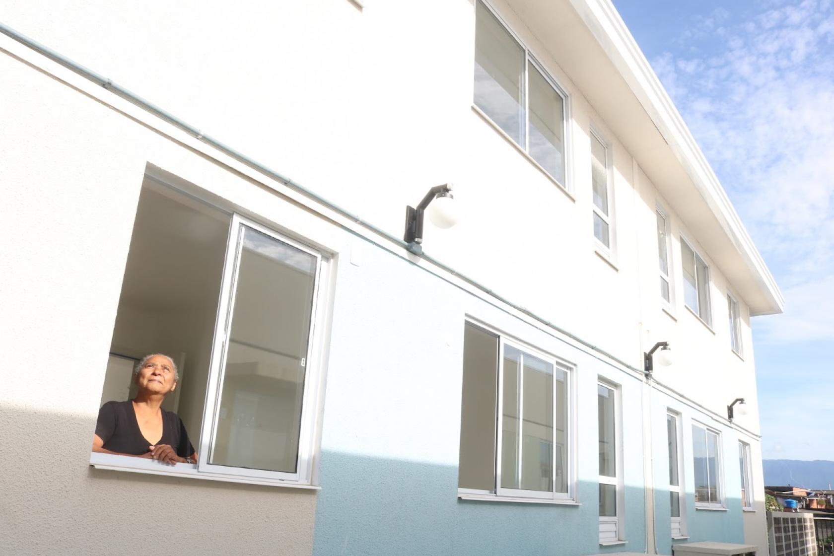 mulher olha para cima em janela de conjunto #paratodosverem