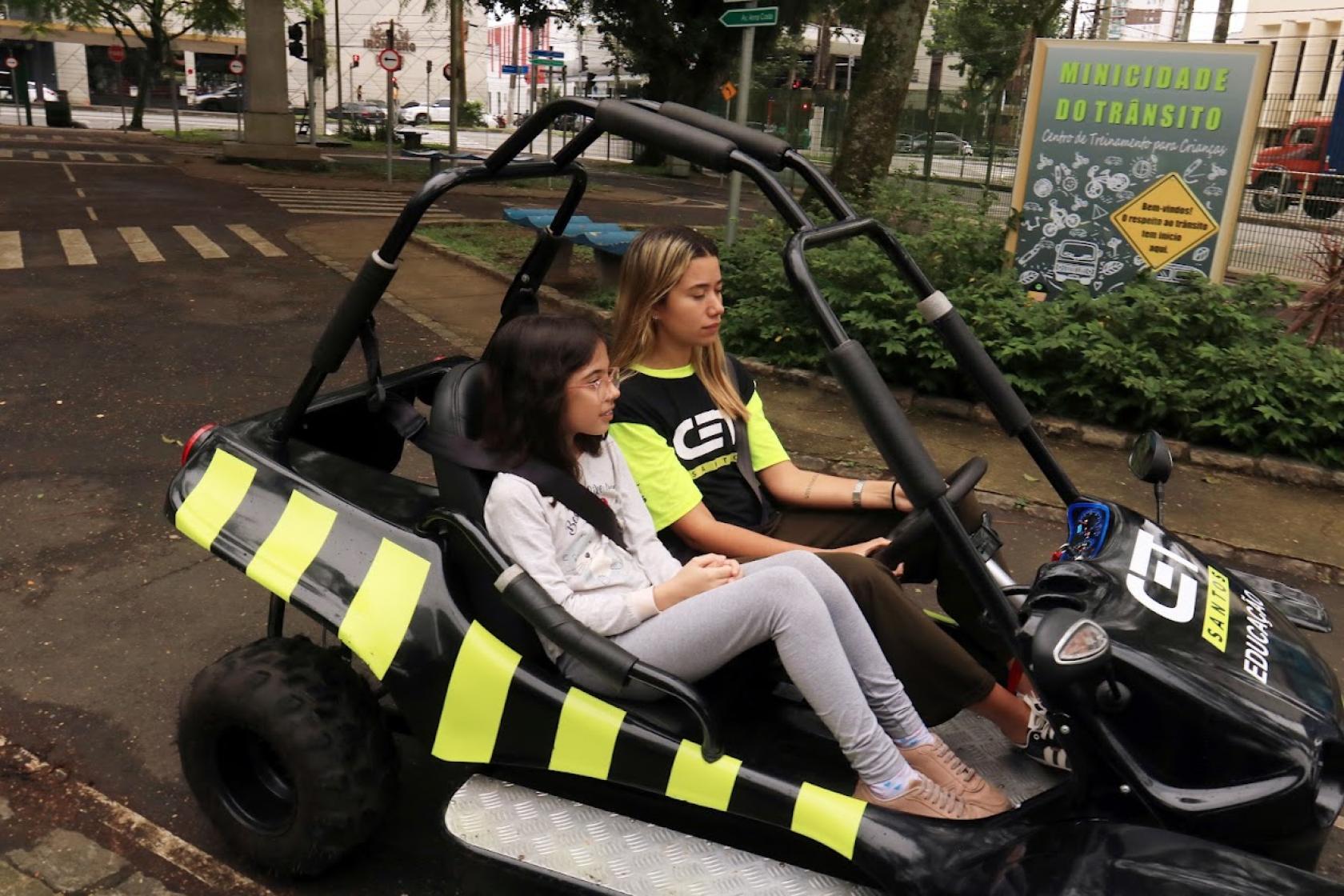 menina anda em minibugue com instrutora #paratodosverem 