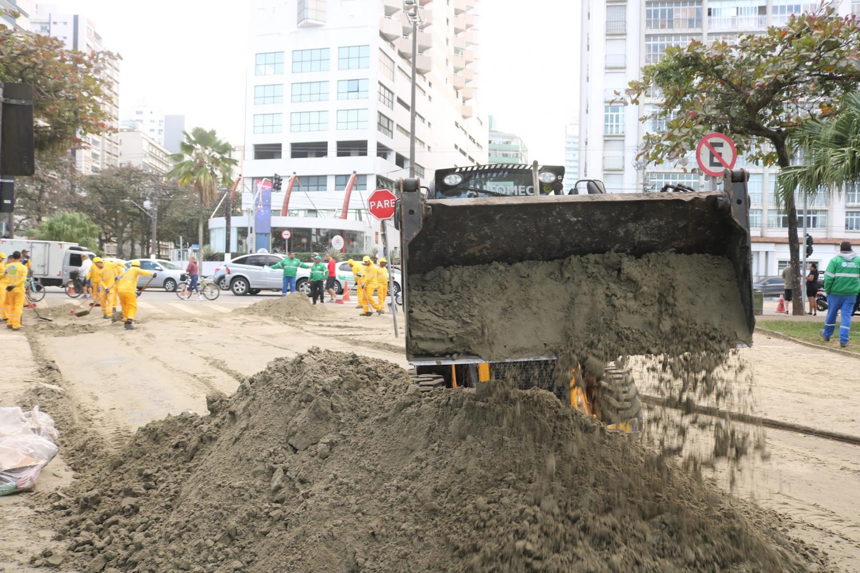 homens e máquina limpam trecho de calçadão e areia da praia. #paratodosverem