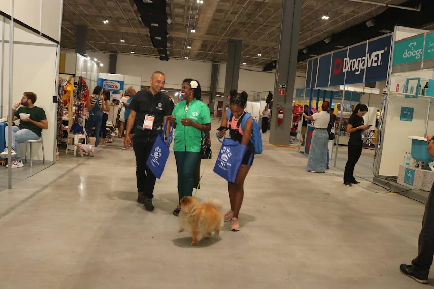 pessoas passeam com cachorro em feira #paratodosverem