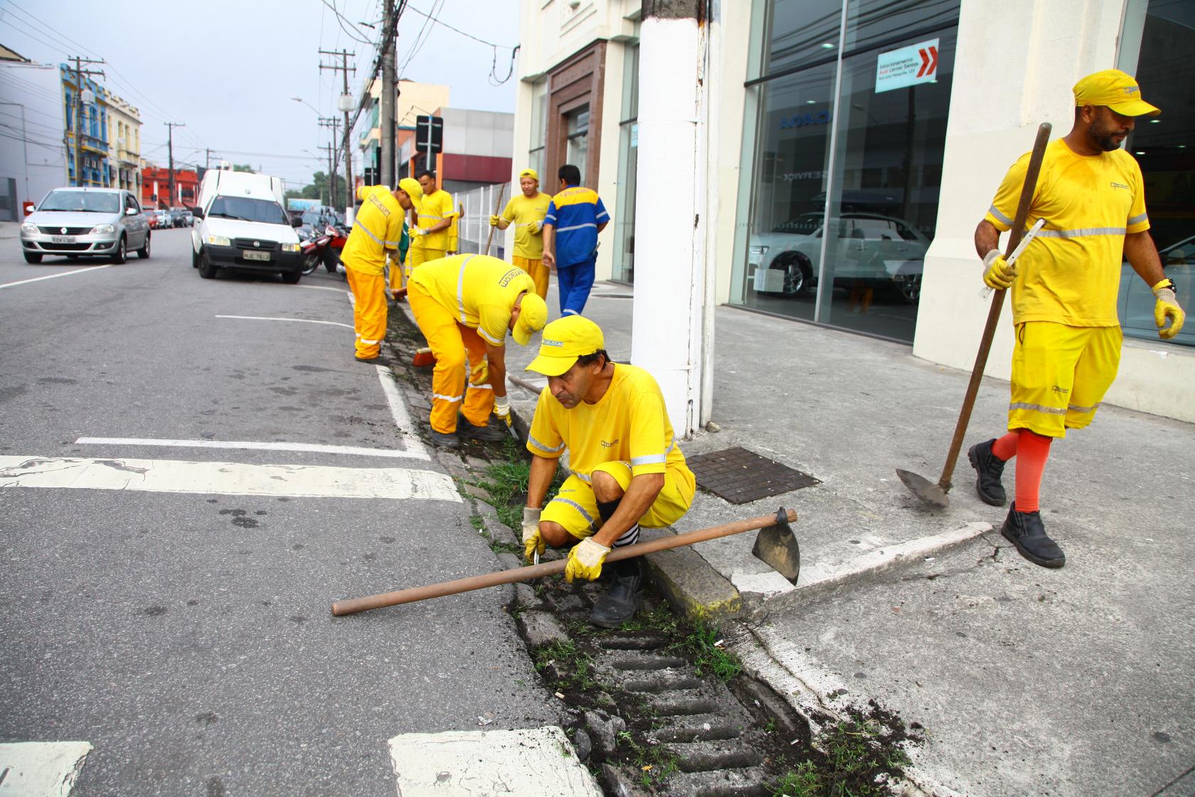 Funcionários limpam sistema de drenagem com acesso por bocas de lobo. #Pracegover
