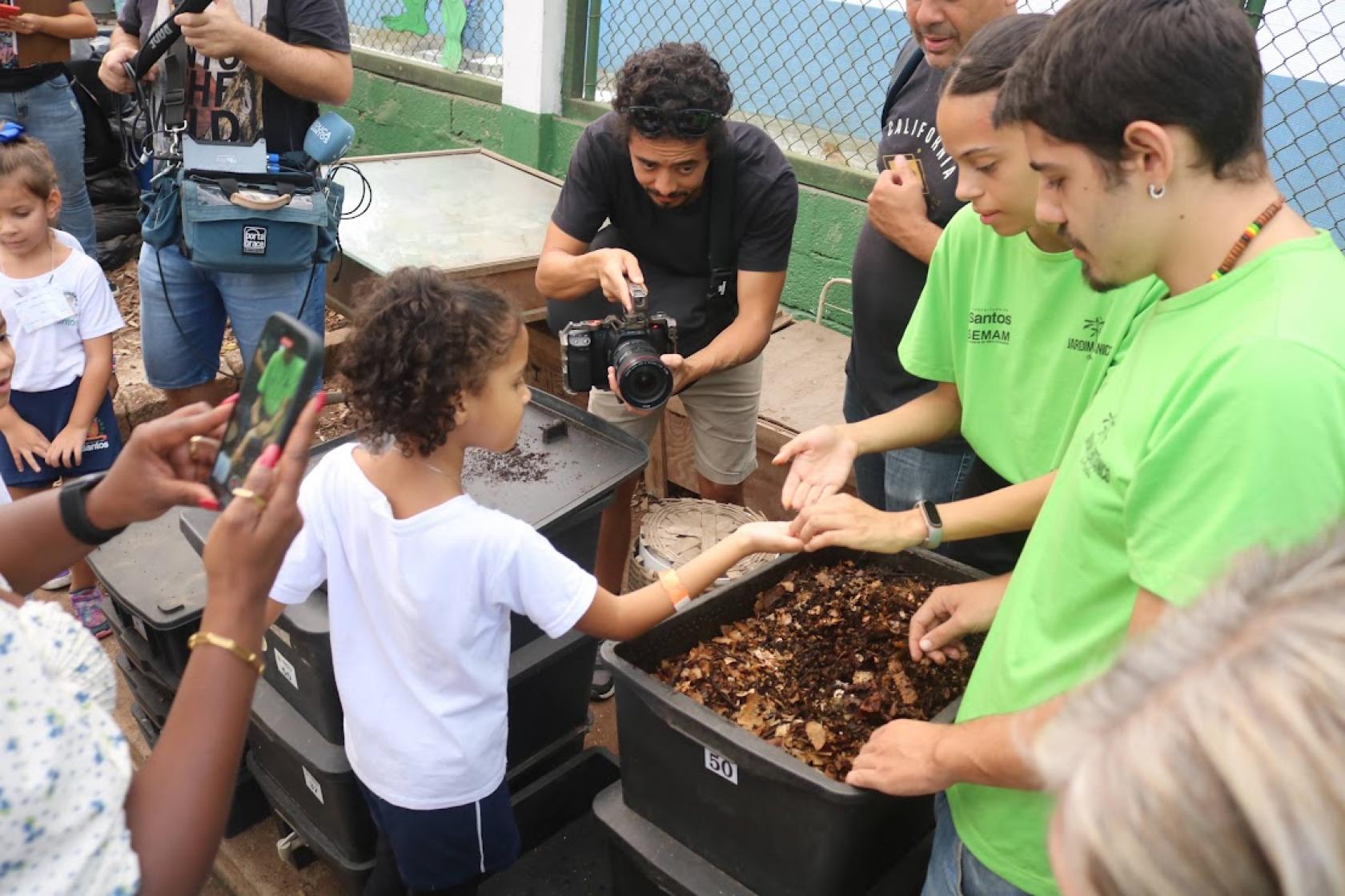 criança tem terra colocada na mão por instrutora #paratodosverem 