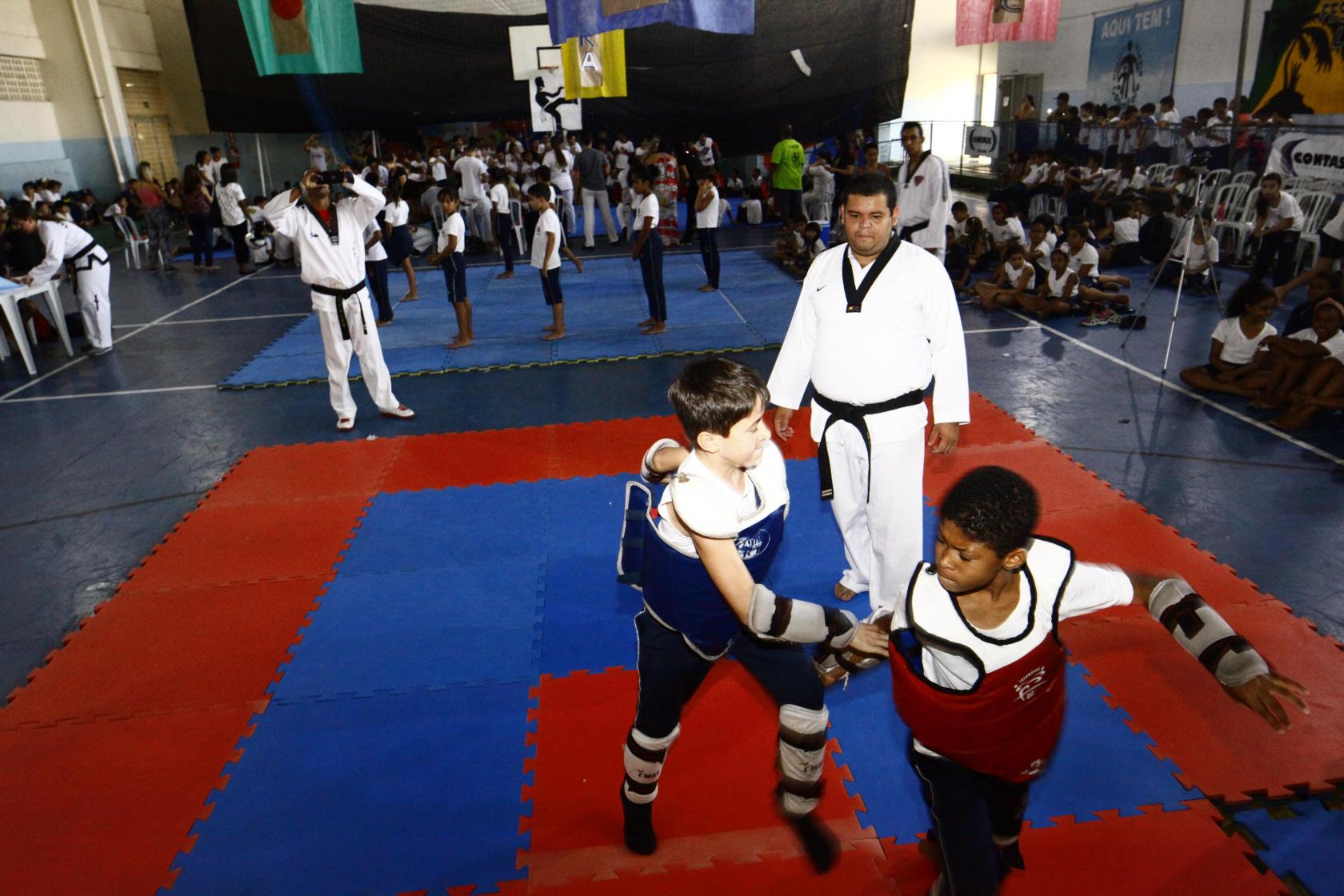 meninos lutam observados por professor #pracegover