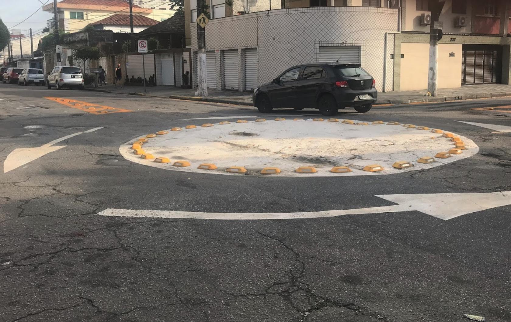 Rotatória com pintura de solo indicando o sentido de movimento. Carro atravessa a rua. #Paratodosverem