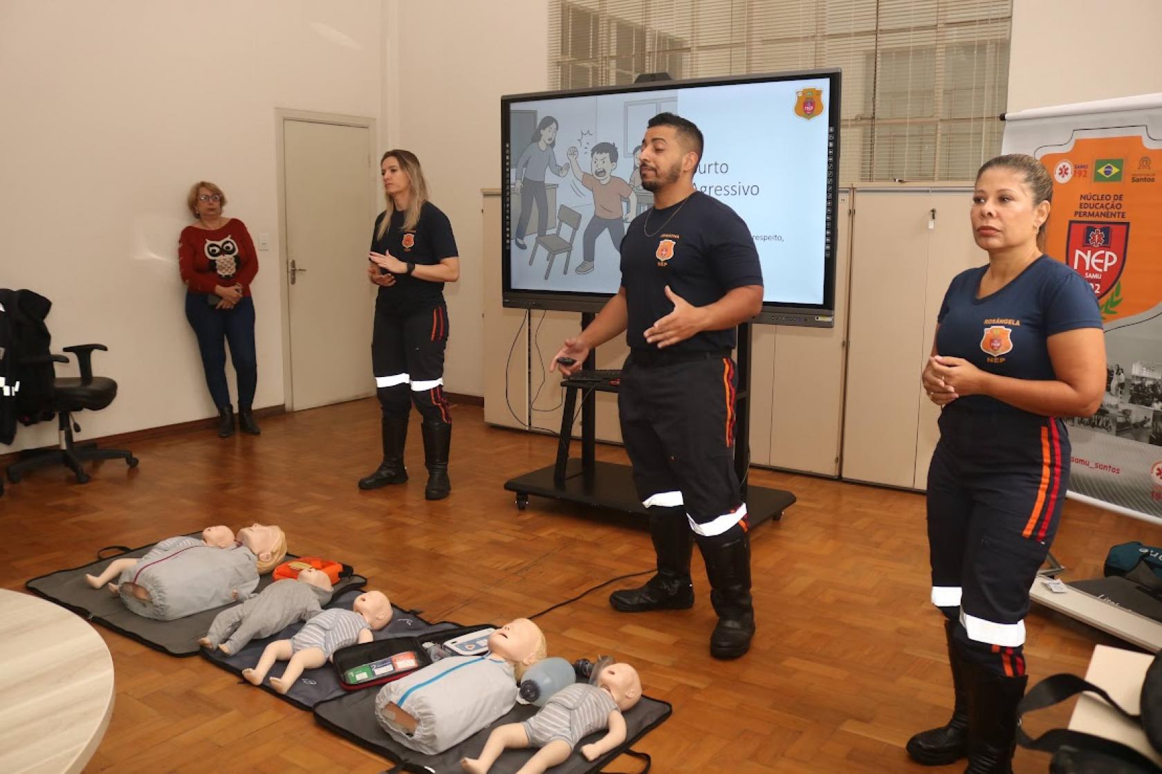 equipe do samu faz demonstração com bonecas no chão #paratodosverem