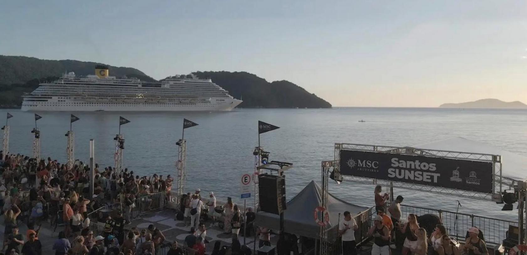 público na avenida de frente para o mar e navio ao fundo. #paratodosverem