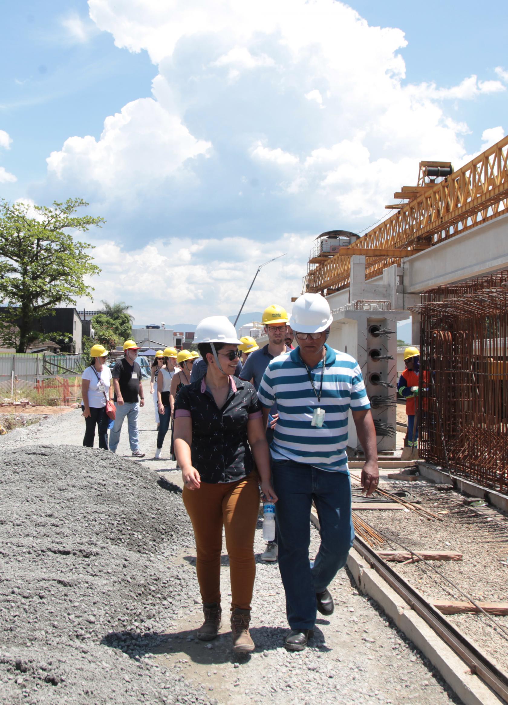 visitantes caminham no meio de obra #pracegover