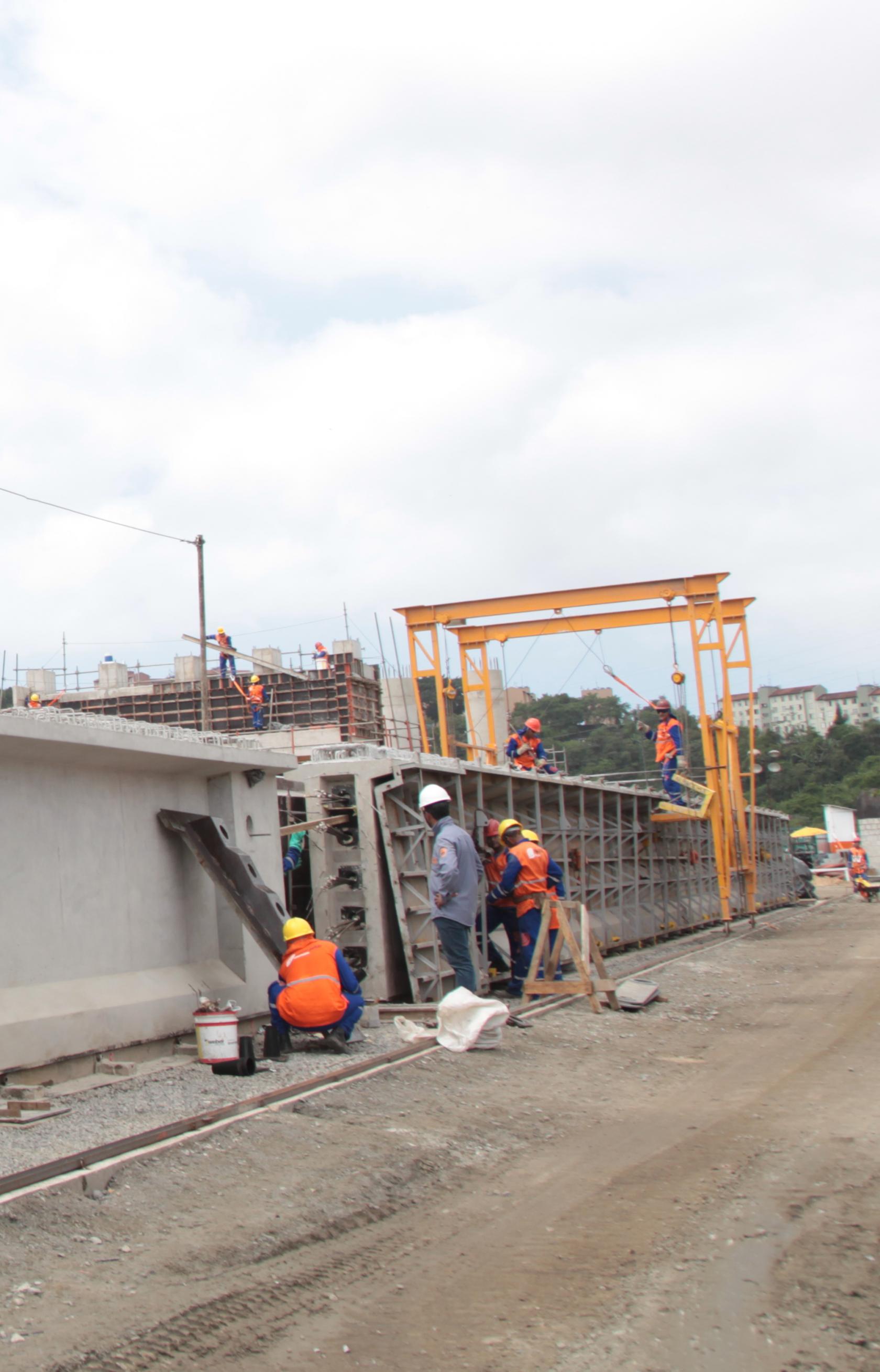 homens trabalhando na lateral da obra #pracegover