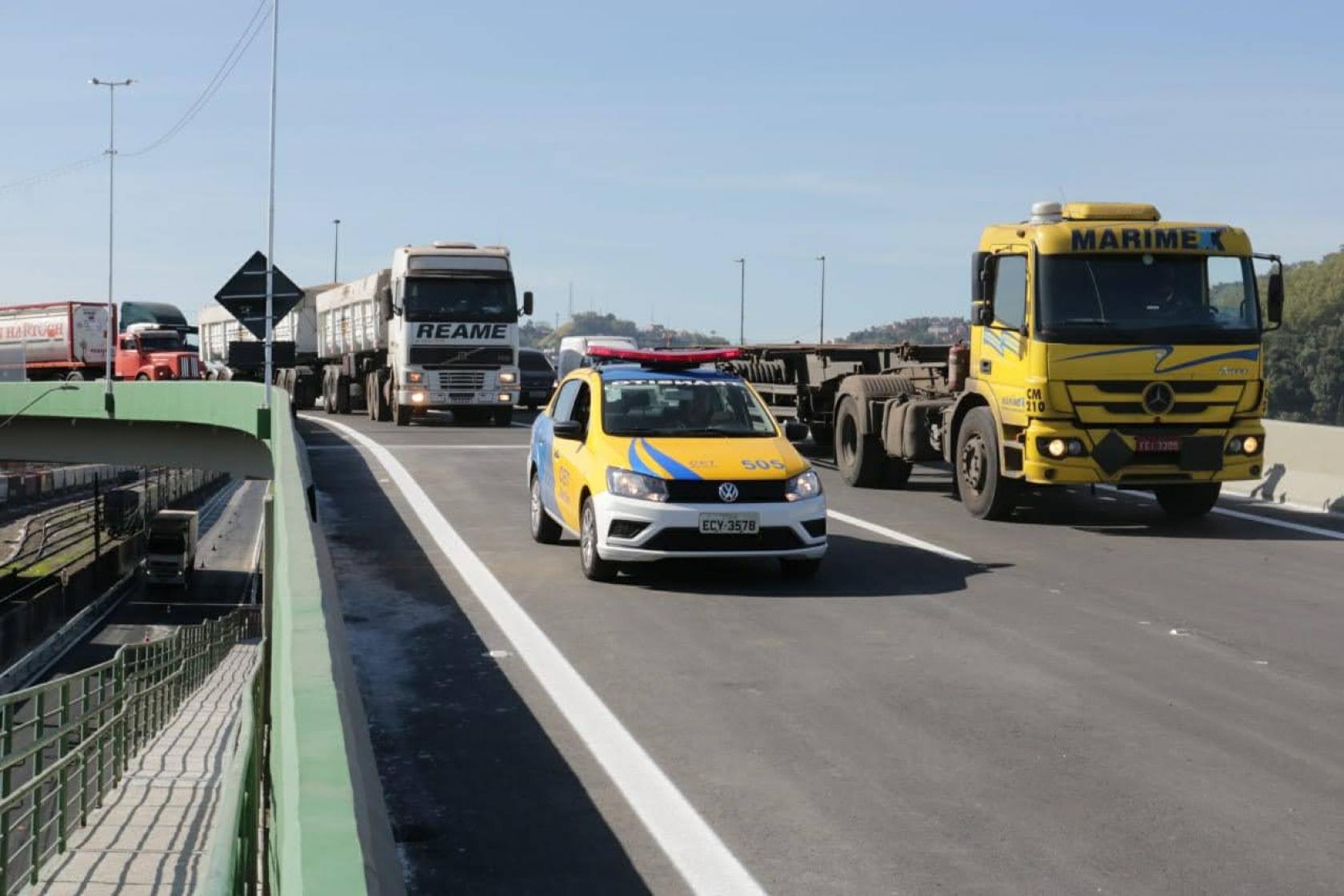 carro da polícia puxa fila de caminhões no novo viaduto #paratodosverem 