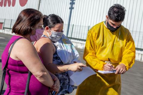 técnico anota dados de mulheres  #paratodosverem