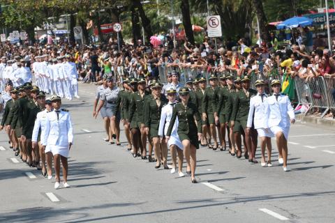 Mulheres militares fardadas desfilam na avenida. #Pracegover