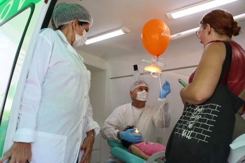 menina é atendida por dentistas em van #pracegover 