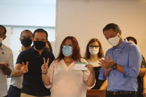 enfermeira vacinada comemora mostrando dois dedos em V #paratodosverem