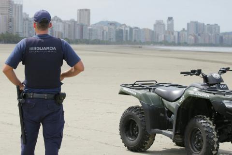 Guarda Municipal está em pé, de costas para a imagem, e ao lado de quadriciclo. #Paratodosverem