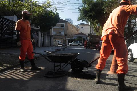 dois operários atuam na limpeza de bueiro #paratodosverem 