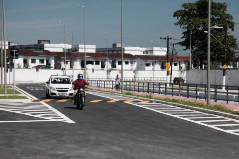 Carro e moto estão na via com pavimentação e pintura novas. #Paratodosverem