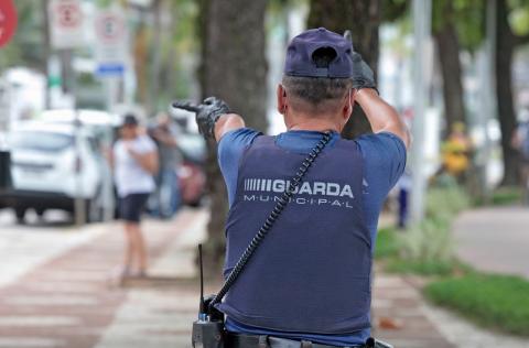 Guarda Municipal orienta pedestre a distância no calçadão. #Paratodosverem