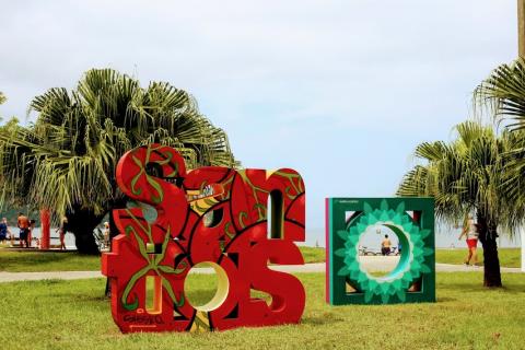 Monumento com a inscrição de Santos e símbolo da mureta estilizados com pintura em grafite. #pracegover