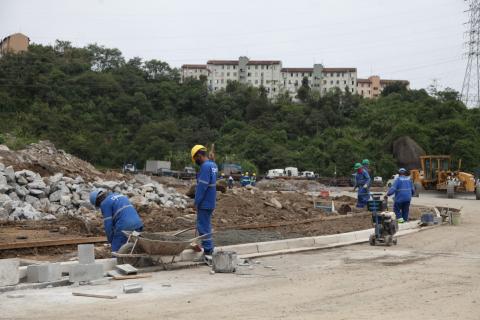 Execução de passeios na avenida Beira Rio. Homens estão trabalhando. Ao fundo há o verde da vegetação. #Paratodosverem