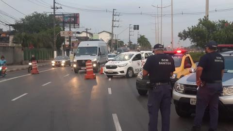 Guardas e veículos estacionados em barreira sanitária na entrada da Cidade. #pracegover