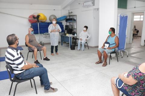 Pacientes estão sentados em roda. Orientadora está em pé. #Paratodosverem