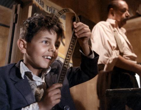 em cena de cinema paradiso, menino olha para negativo #pracegover 