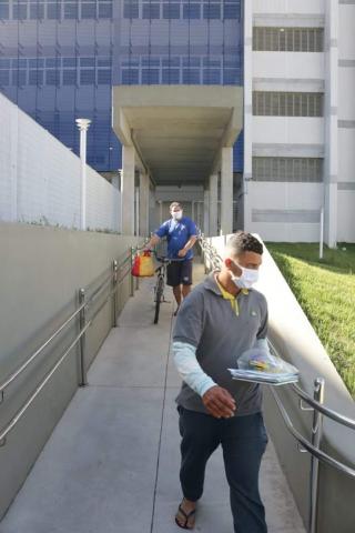 Homens estão saindo por rampa de escola com material nas mãos. #Paratodosverem