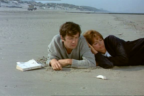 casal sentado na praia em eu te amo eu te amo #pracegover 