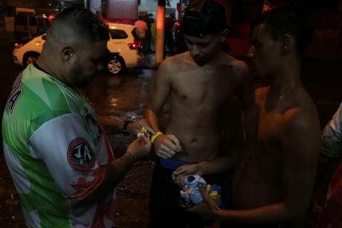 Integrante da banda coloca pulseira em folião. #Pracegover