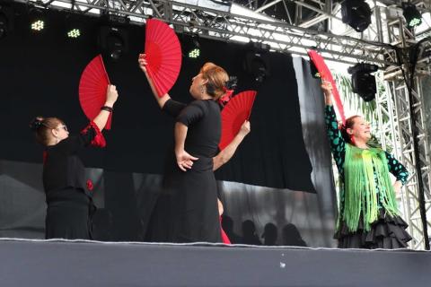 Dançarinas espanholas se apresentam no palco com leques. #pracegover